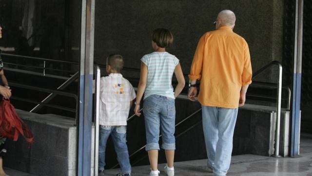 Un padre junto a sus hijos en una imagen de archivo.