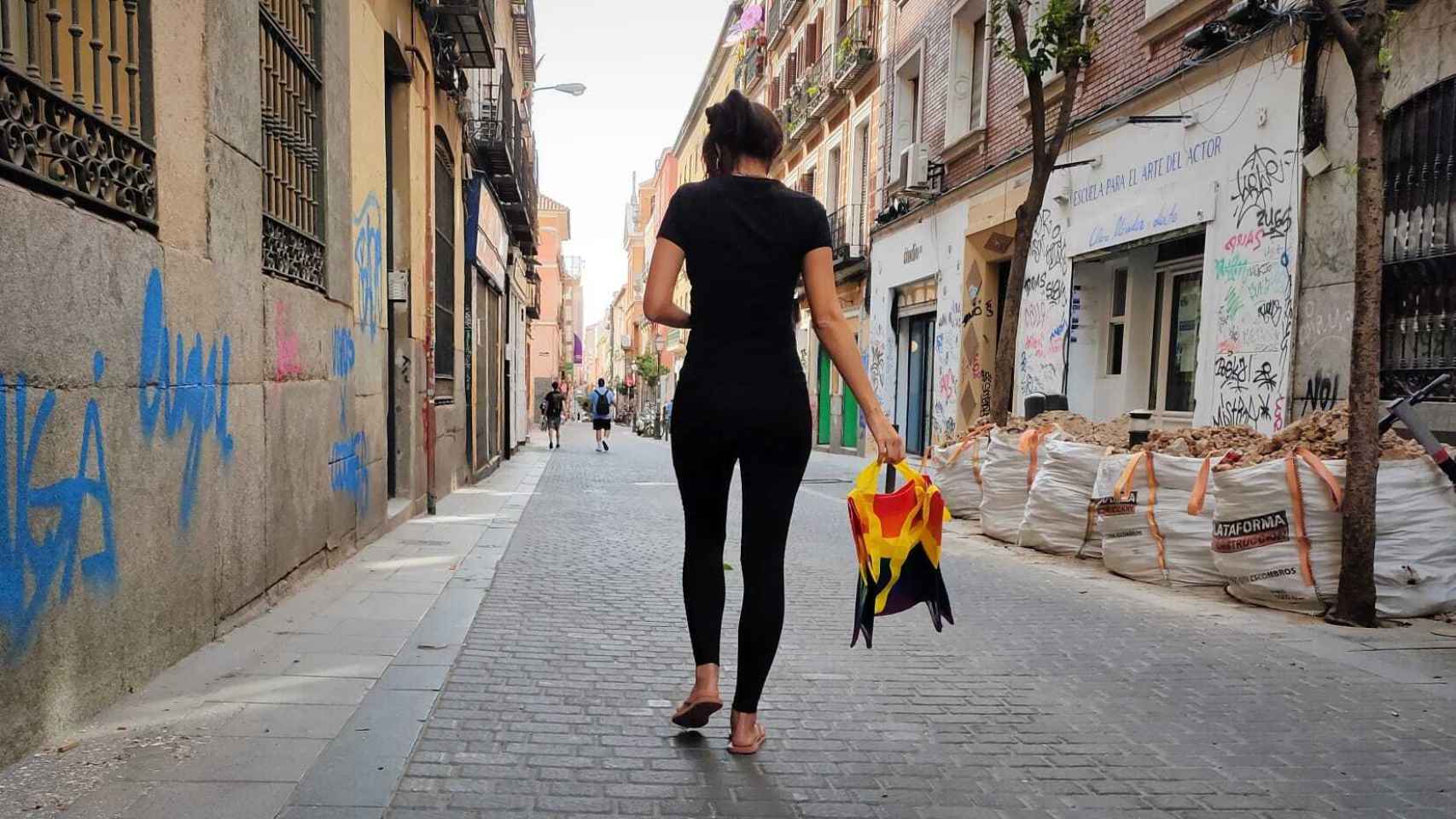 Una vecina de Malasaña pasea con una bolsa con la bandera arcoíris.