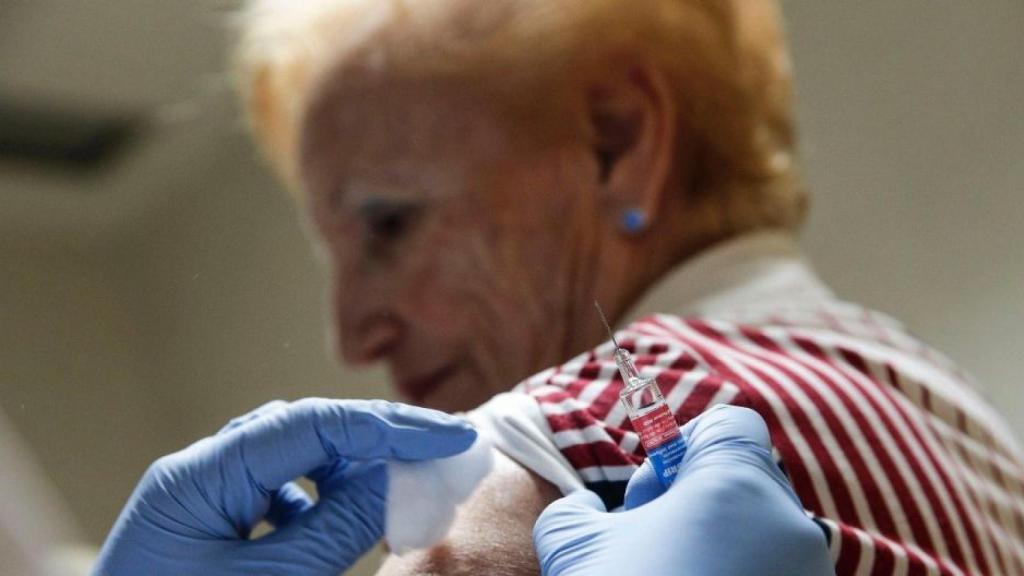 Una mujer recibe una vacuna contra la gripe.