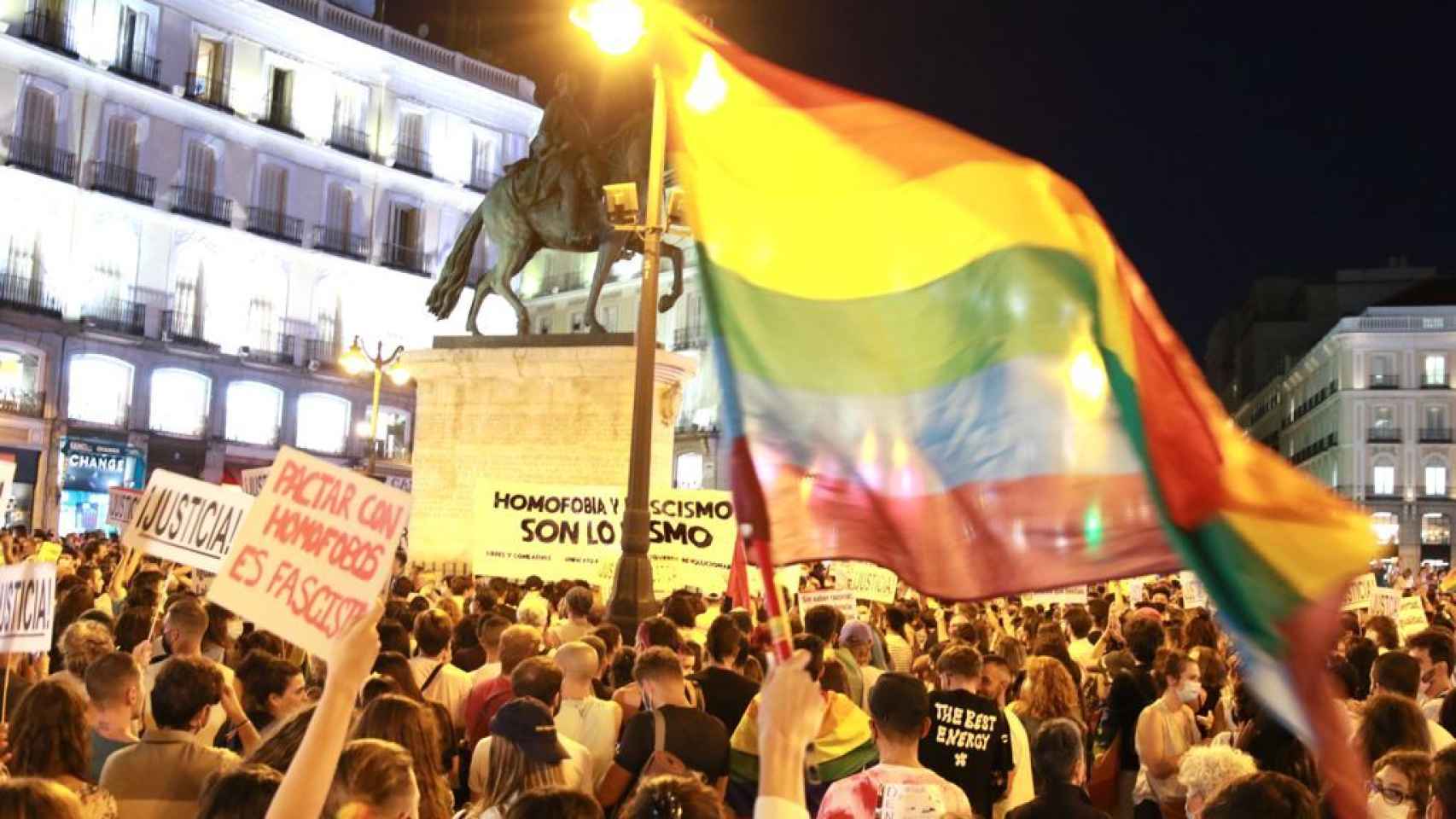 Los manifestantes ondean una bandera LGTBI durante la protesta en Madrid.