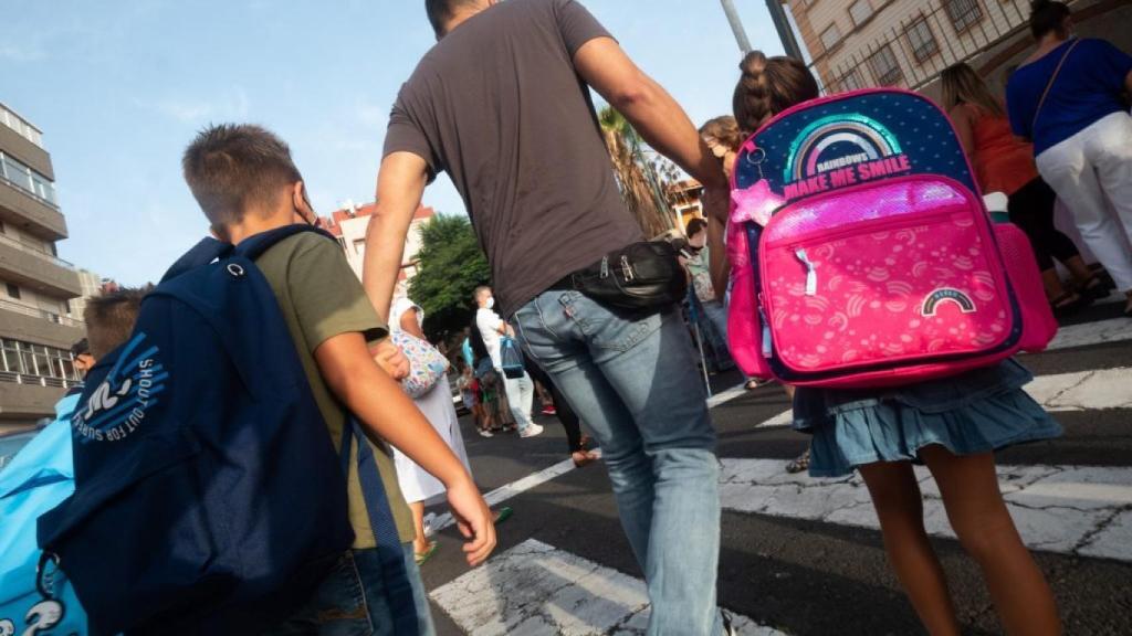 Un padre lleva a sus hijos al colegio