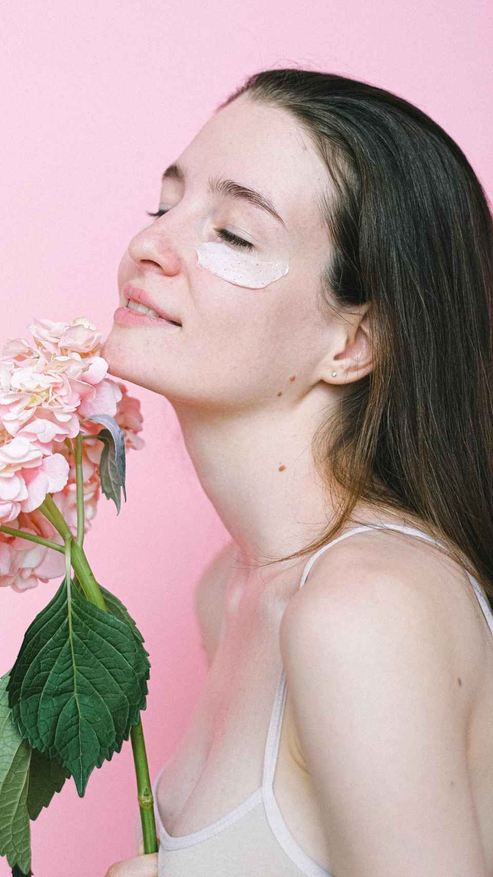Chica aplicando crema hidratante en la cara.