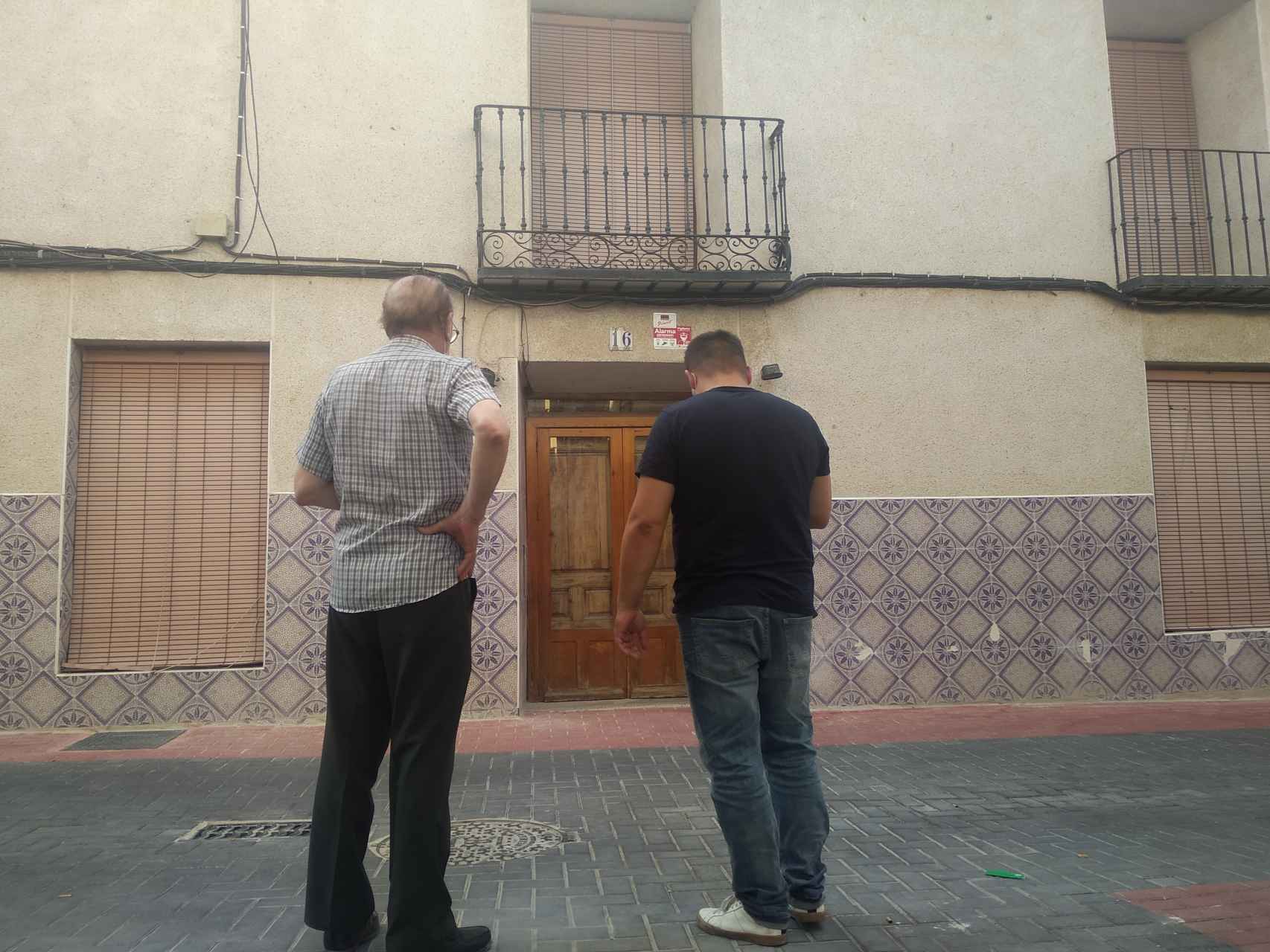 Dos vecinos frente a la casa de Pepe 'El Melón' donde supuestamente retuvo a su pareja.