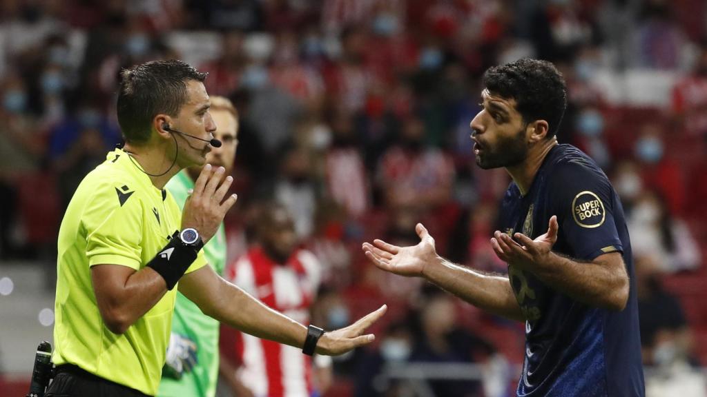 El árbitro Hategan hablando con Mehdi en el Atleti - Oporto