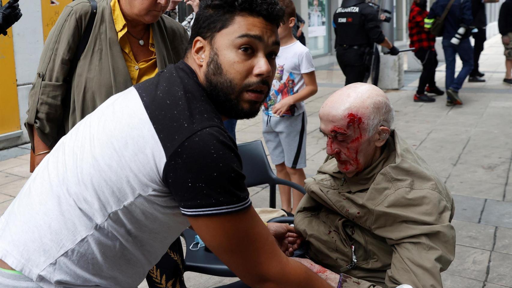 Un hombre es atendido tras resultar herido durante los disturbios.