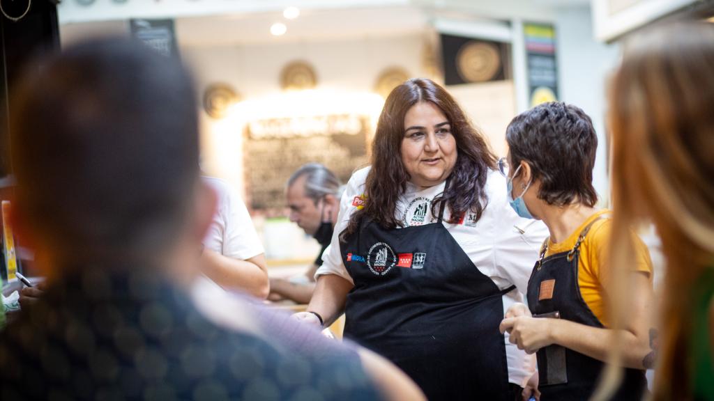 Lucía Mora, cocinera, hablando con una colega de profesión en el Mercado de Antón Martín.