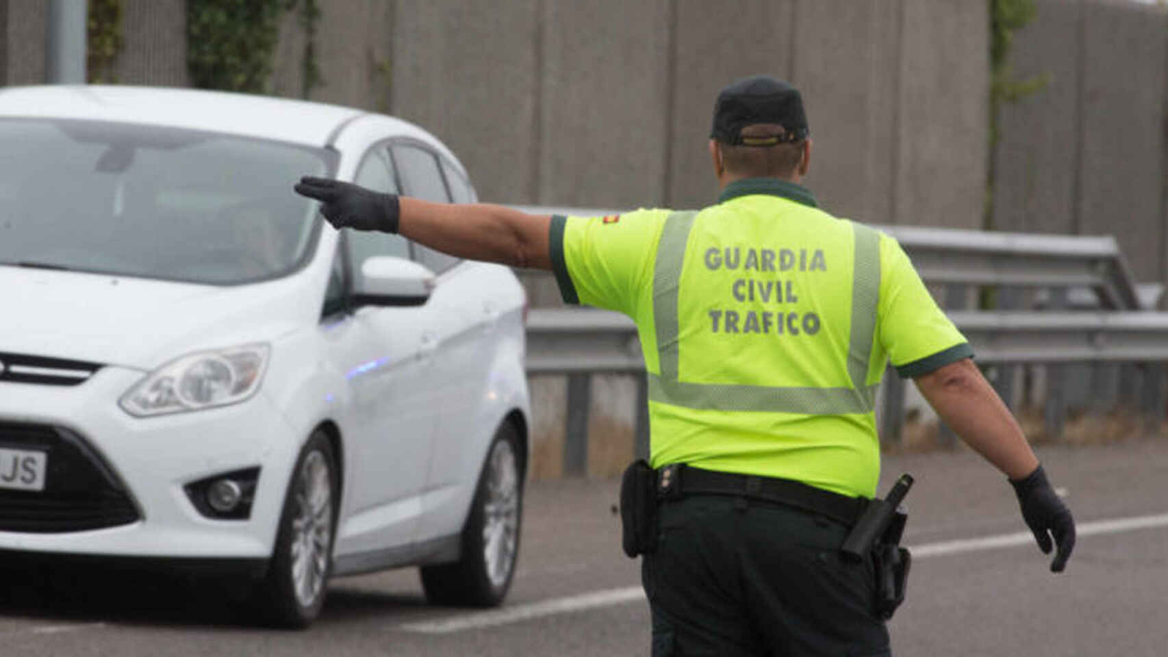 Un agente de la Guardia Civil ordena a un vehículo detenerse.