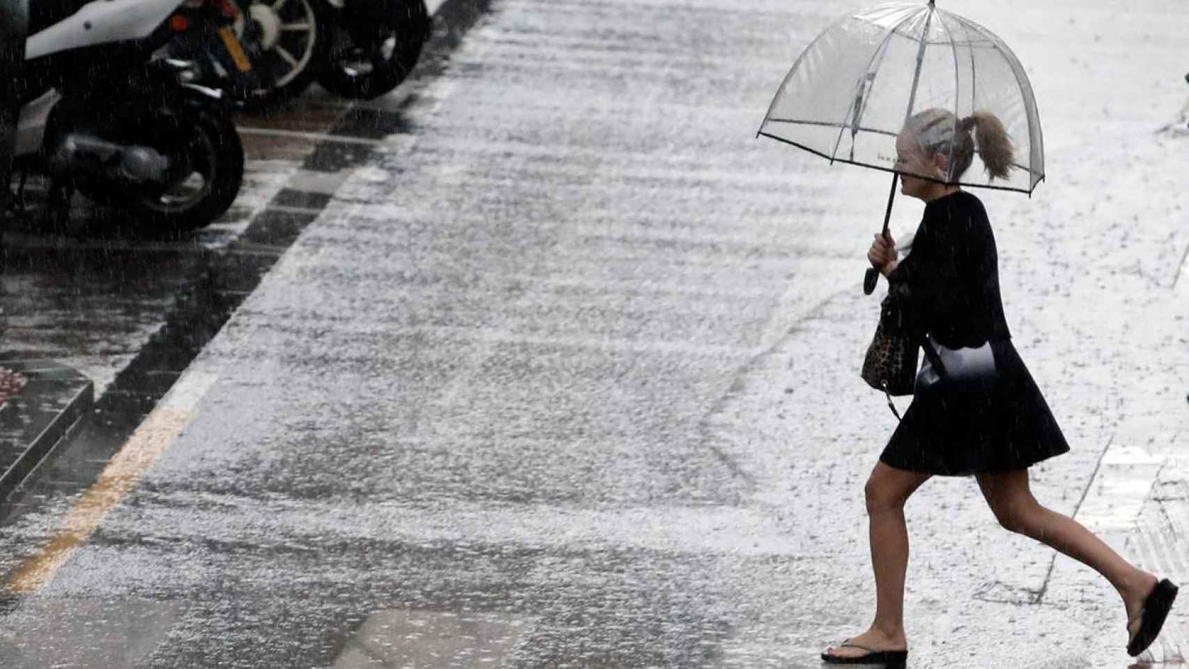 Uan mujer sostiene un paraguas mientras llueve.