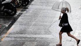 Uan mujer sostiene un paraguas mientras llueve.