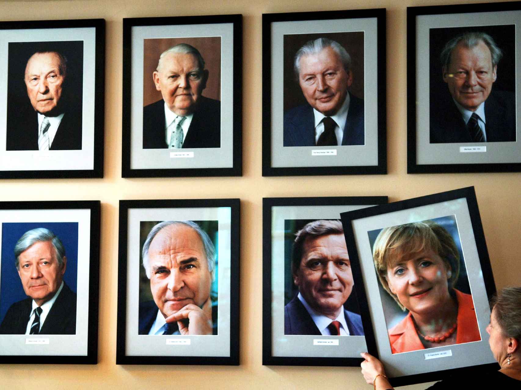 La imagen de la canciller alemana Angela Merkel, colgada en una pared con los retratos de los excancilleres (arriba, de izquierda a derecha) Konrad Adenauer, Ludwig Erhard, Kurt Georg Kiesinger, Willy Brandt, (abajo, de izquierda a derecha) Helmut Schmidt, Helmut Kohl y Gerhard Schroeder.