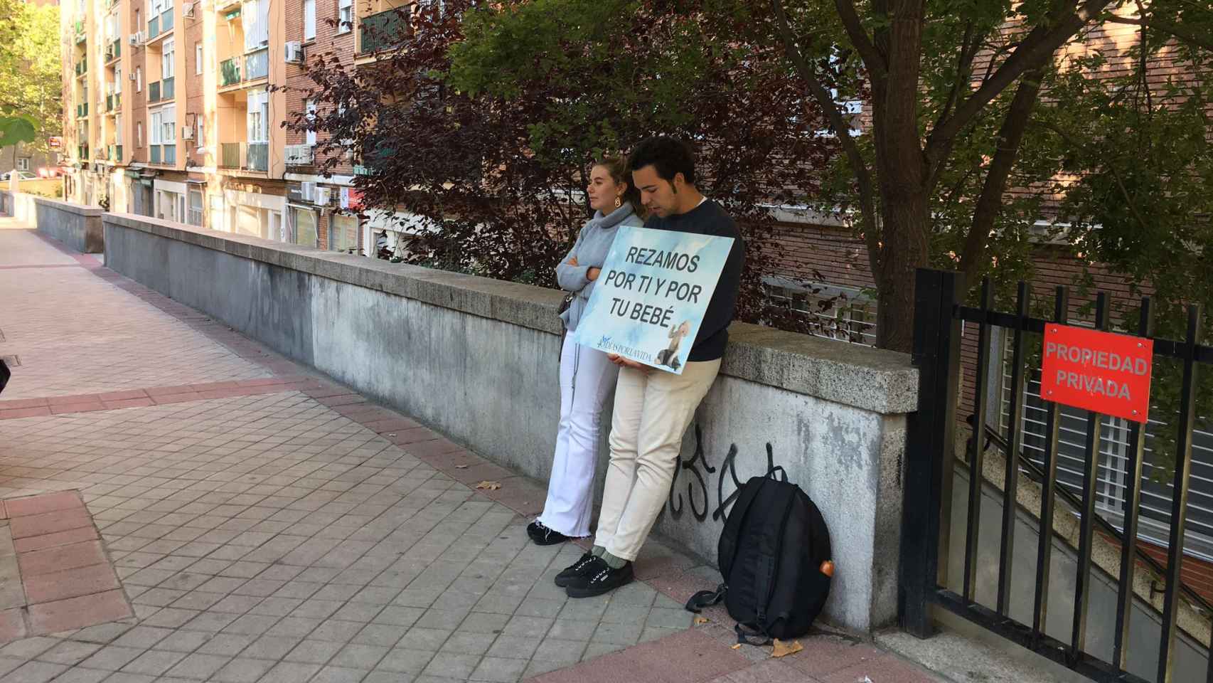 Dos jóvenes sostienen un cartel frente a la clínica Dator de Madrid.