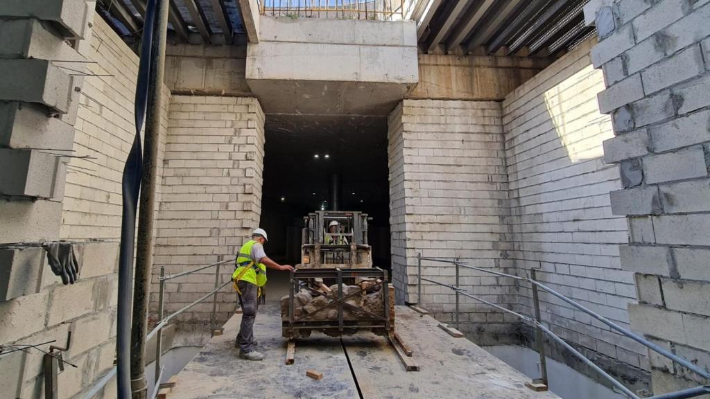 Varios operarios trasladan parte de los restos arqueológicos del Metro de Málaga.