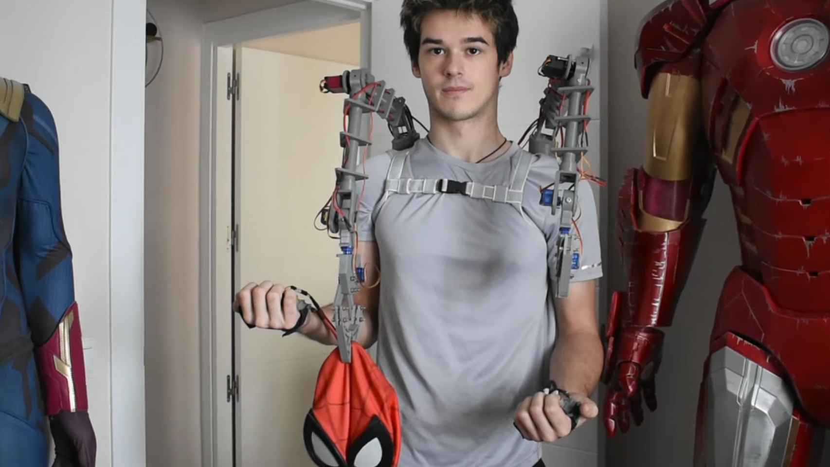 Los brazos mecánicos sujetando una máscara de Spider-Man.