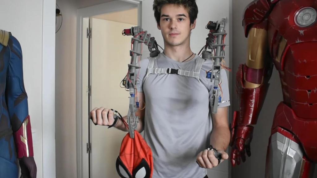 Los brazos mecánicos sujetando una máscara de Spider-Man.