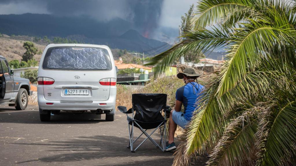 Unos turistas miran el volcán desde un aparcamiento en Los Llanos.