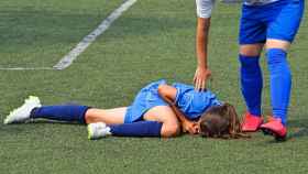 Una futbolista tendida sobre el césped dolorida tras sufrir una lesión