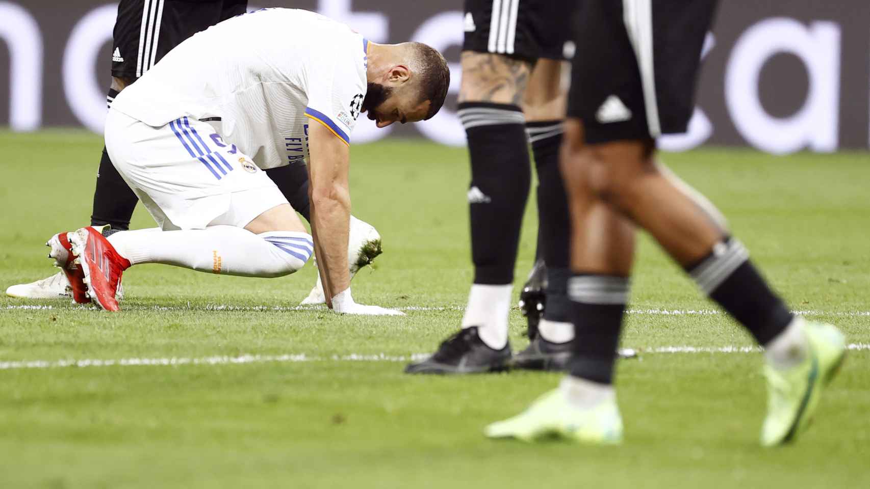 Karim Benzema agachado mira al césped