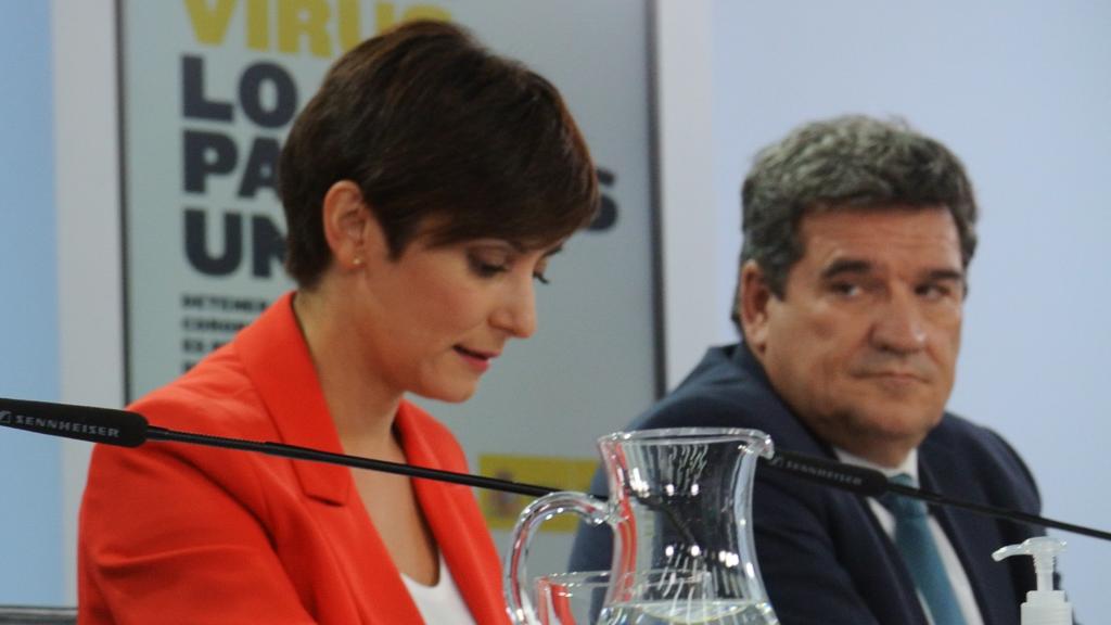 Yolanda Díaz y José Luis Escrivá, separados por la portavoz, Isabel Rodríguez, en la sala de prensa de Moncloa.