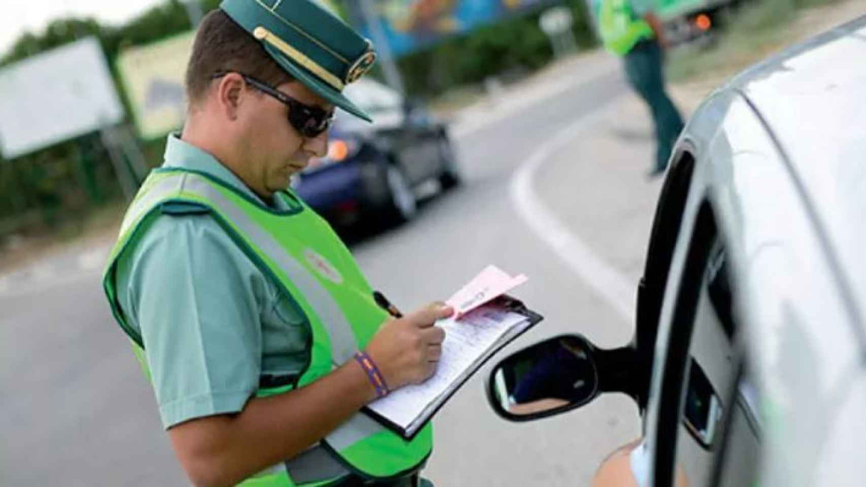 Un guardia civil pone una multa de tráfico.