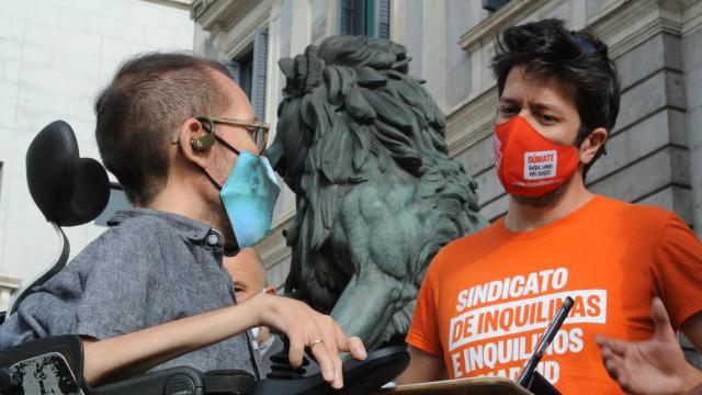 Pablo Echenique, portavoz de Unidas Podemos, con un activista del Sindicato de Inquilinas, ante los leones del Congreso.