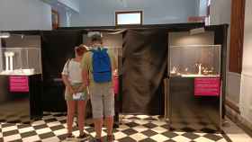 Dos visitantes contemplando la exposición en la sala de exposiciones del Palacio Provincial.