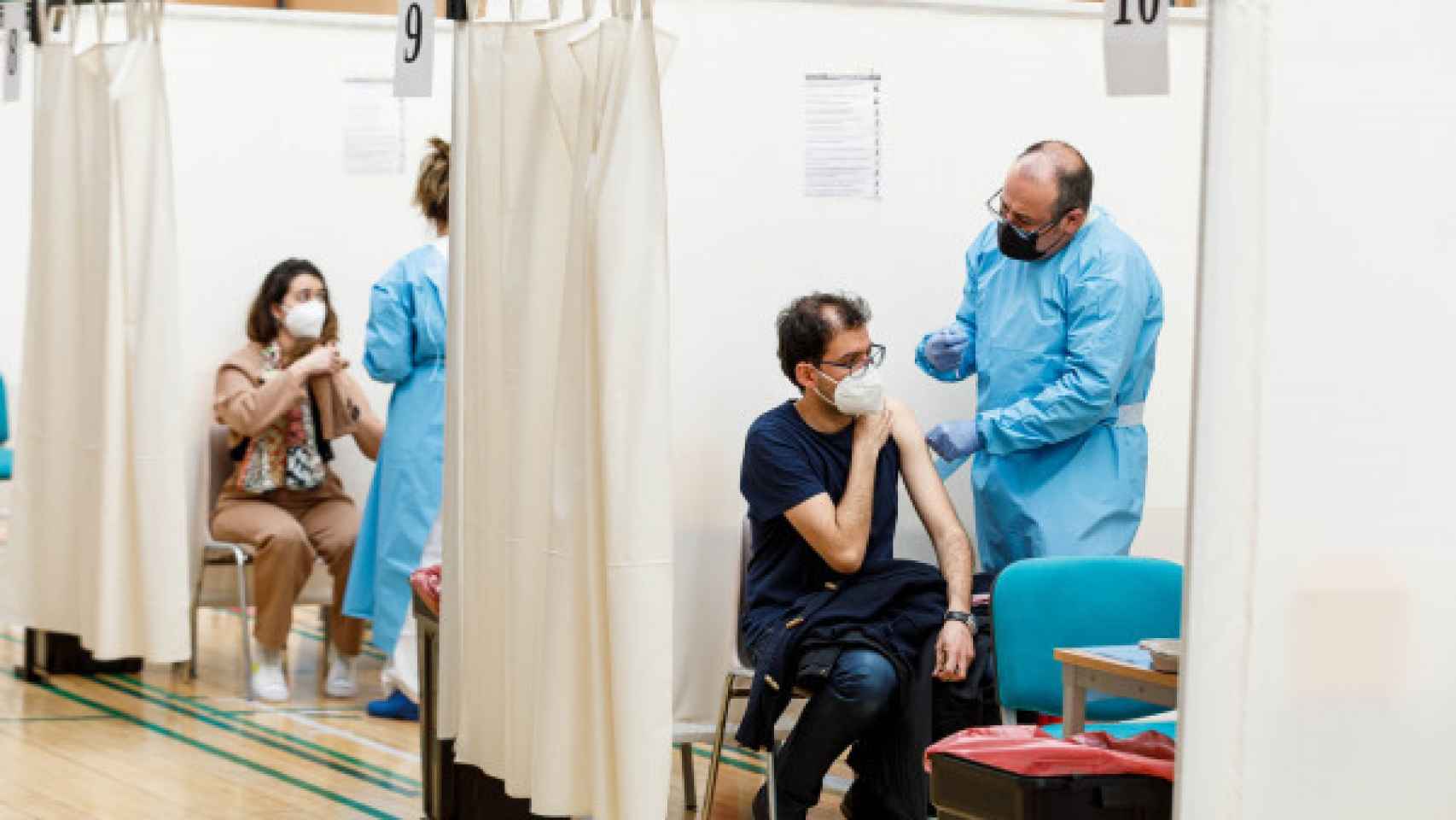 Dos sanitarios inyectan la vacuna contra la Covid en un centro de vacunación.