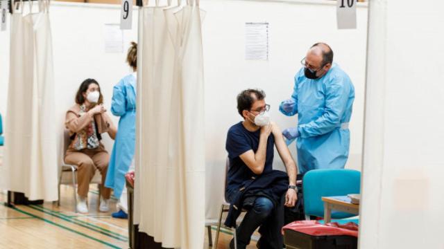 Dos sanitarios inyectan la vacuna contra la Covid en un centro de vacunación.