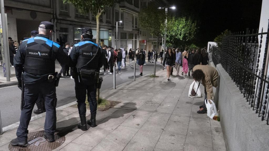 Agentes de policía vigilan las aglomeraciones de grupos de jóvenes en la vía pública de Santiago de Compostela.