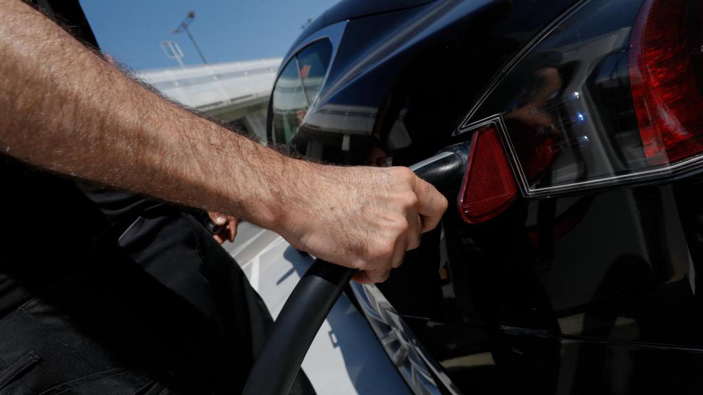 Un usuario cargando un coche eléctrico.