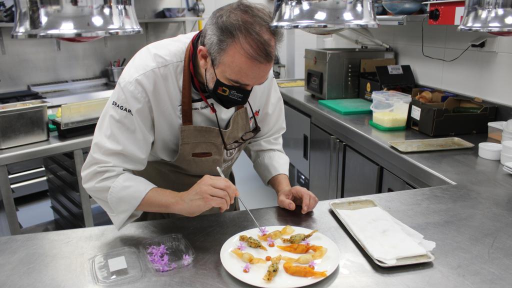 El chef Iñaki Rodaballo decora con flores de ajo su ración de patatas 'candy crunch brava'.