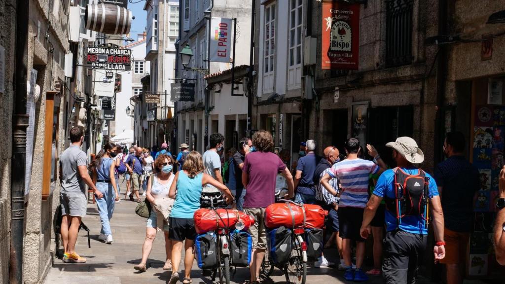 Varios peregrinos caminan con su bicicleta por la Rua do Franco