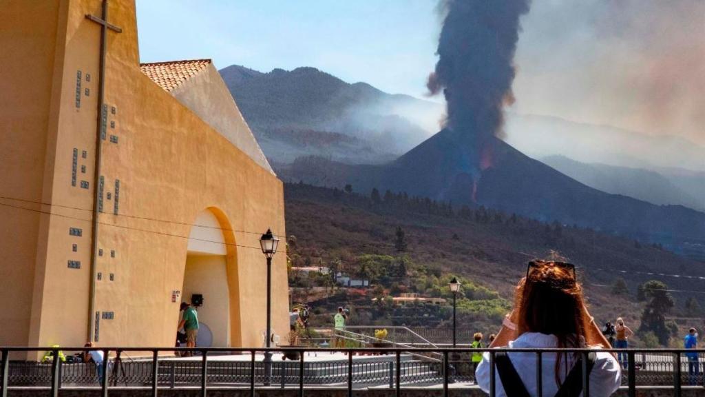 Una joven mirando la erupción del volcán de La Palma.