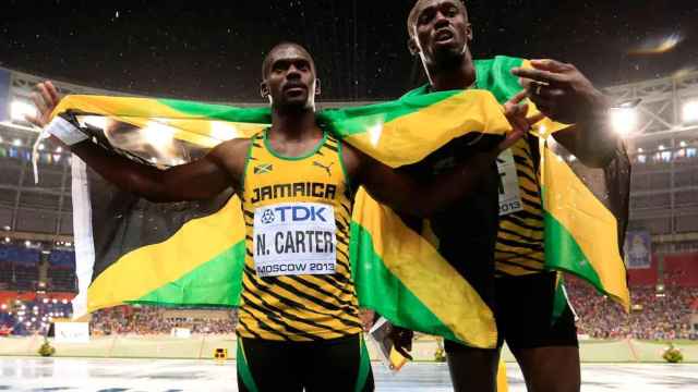 Nesta Carter y Usain Bolt con la bandera de Jamaica tras una competición
