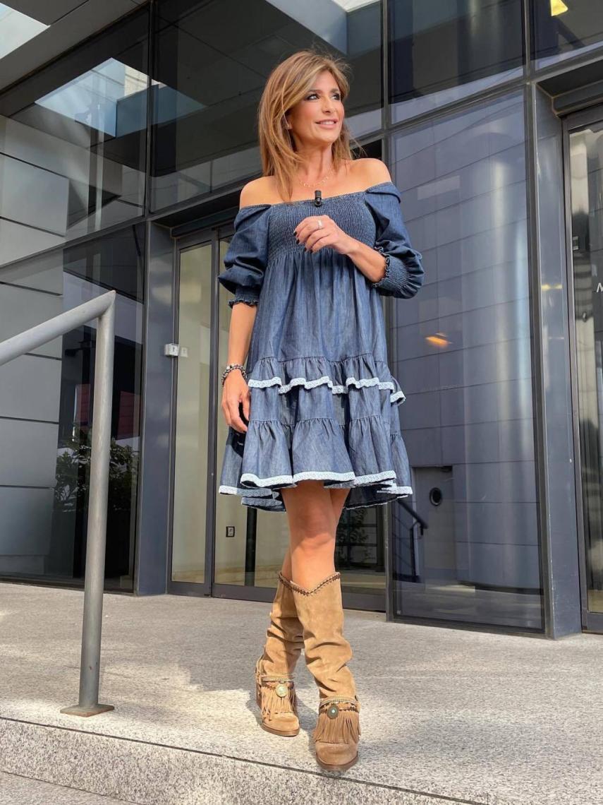 Gema López luciendo un 'outfit' boho, formado por un vestido vaquero y unas botas marrones.