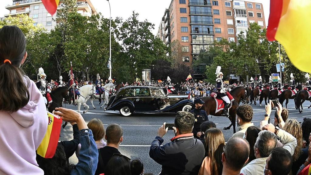 El coche oficial con los reyes Felipe y Letizia pasa por las calles del centro de Madrid.