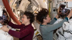 Las astronautas de la NASA Christina Koch y Jessica Meir trabajan en sus trajes antes de una caminata espacial.
