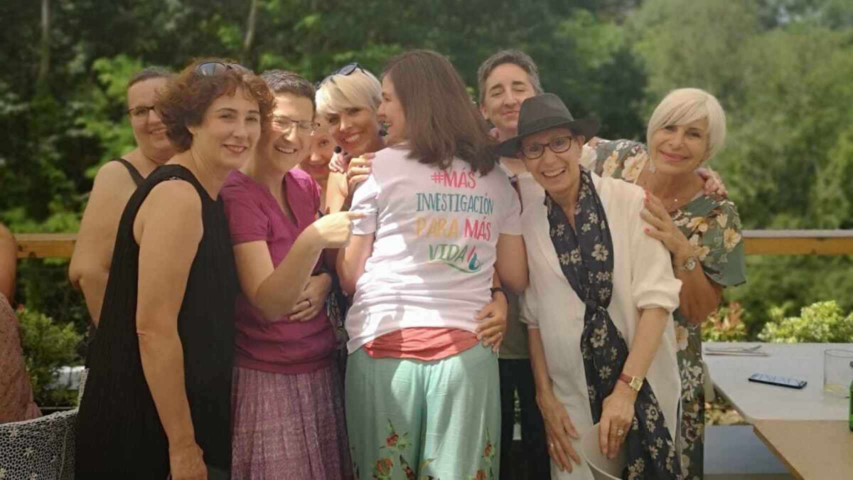 María Caffarel en un encuentro con las pacientes de la asociación Cáncer de Mama Metastásico (CMM) en la que lleva una camiseta con su lema: #másinvetigacionparamásvida. Posando con sombrero negro, su amiga Maite.