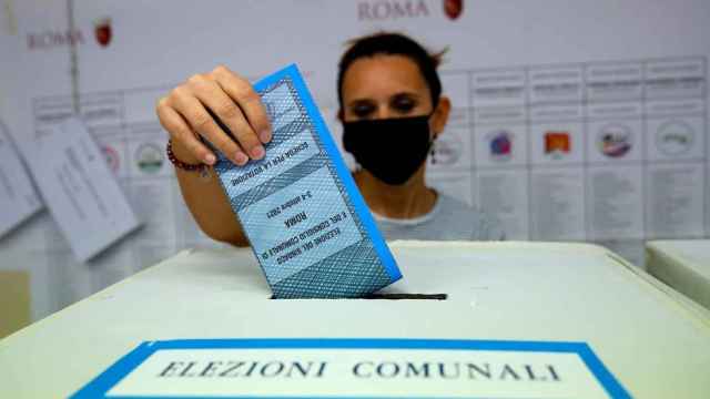 Una mujer deposita su voto en una urna en Roma.
