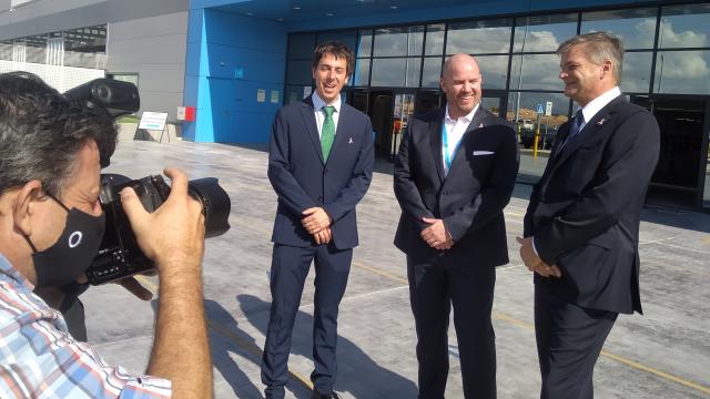 Víctor Romía, Will McLean, y Fred Pattje , en la fachada del nuevo centro logístico Amazon Robotics.