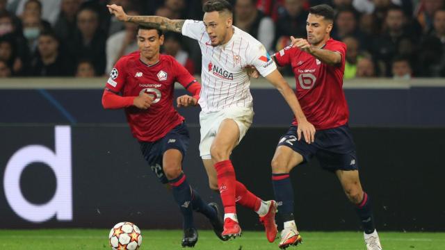 Lucas Ocampos se lleva el balón ante la presión de Zeki Celik y Benjamin André, en el Lille - Sevilla