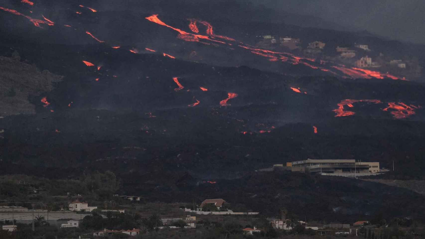 Vista del volcán y la colada desde el municipio de Tazacorte, en la isla de La Palma, este viernes.
