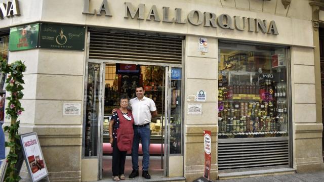 Dolores Medina Jiménez y su hijo posan frente al escaparate de La Mallorquina.