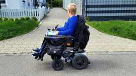 Una mujer pasea en su silla de ruedas.