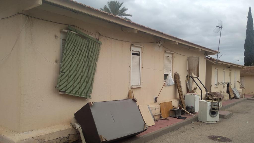 Enseres amontonados en una calle de las viviendas sociales del Barrio del Colegio de Campos del Río.