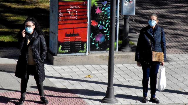 Dos mujeres con mascarilla esperan en el paso de peatón de La Farola