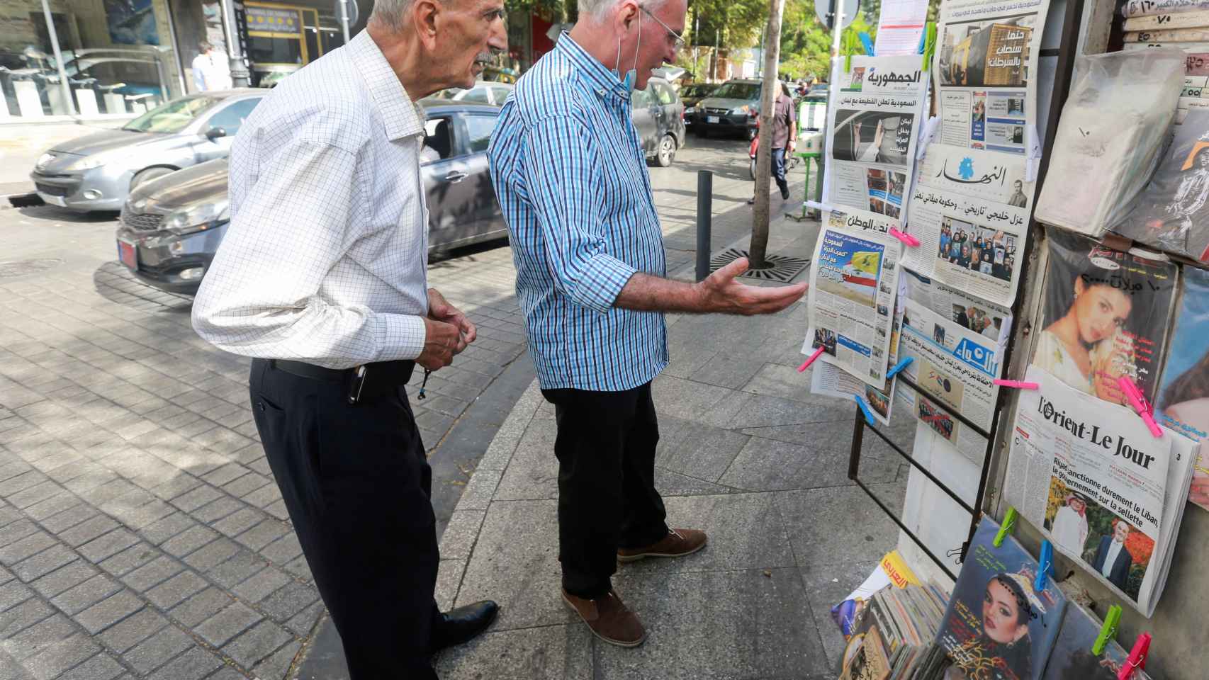 Dos hombres leen los titulares de periódicos libaneses que anuncia las medidas de los países del Golfo.