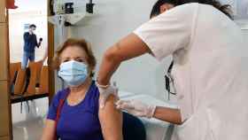 Una enfermera vacuna a una mujer.