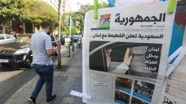 Un hombre camina en Beirut al lado de un periódico libanés que titula con Araba Saudí anuncia un boicot contra el Líbano.