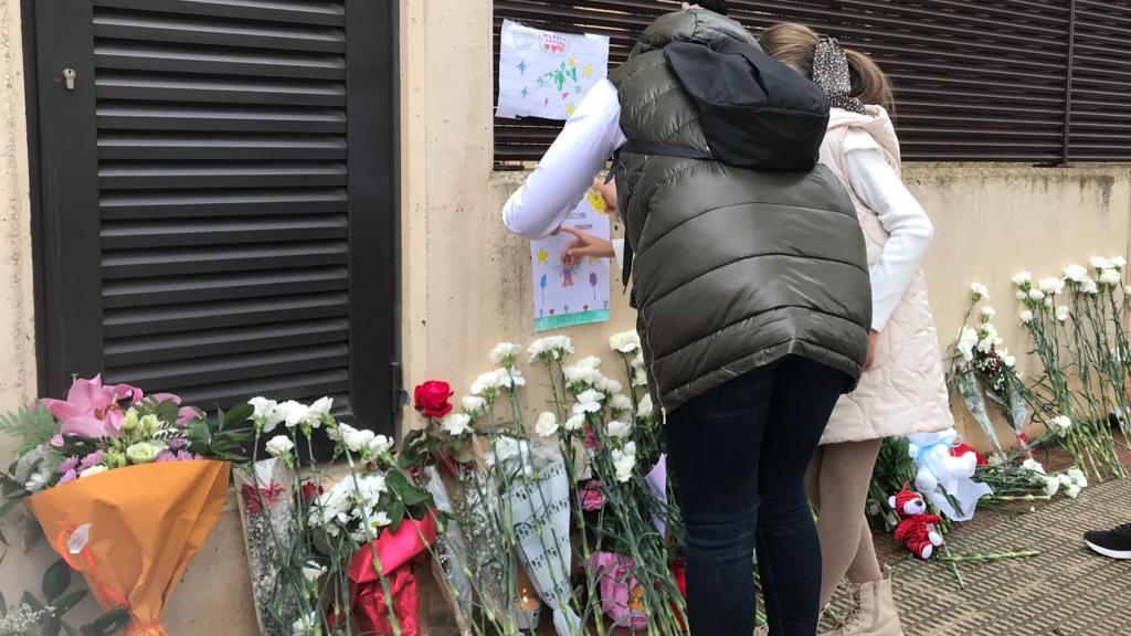 Una madre y su hija pegan una carta para Álex en el bloque donde lo mataron.