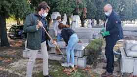 Los Fernández limpian la tumba de sus seres queridos.